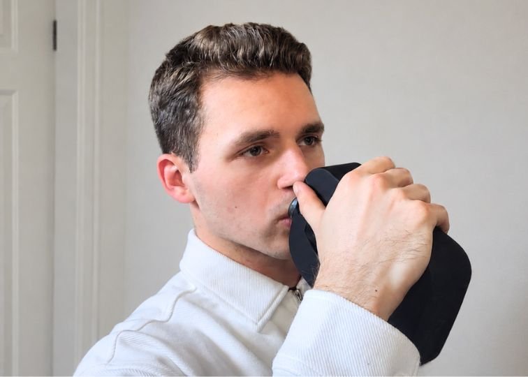 Jeremiah Kowalski drinking from a black reusable bottle during testing