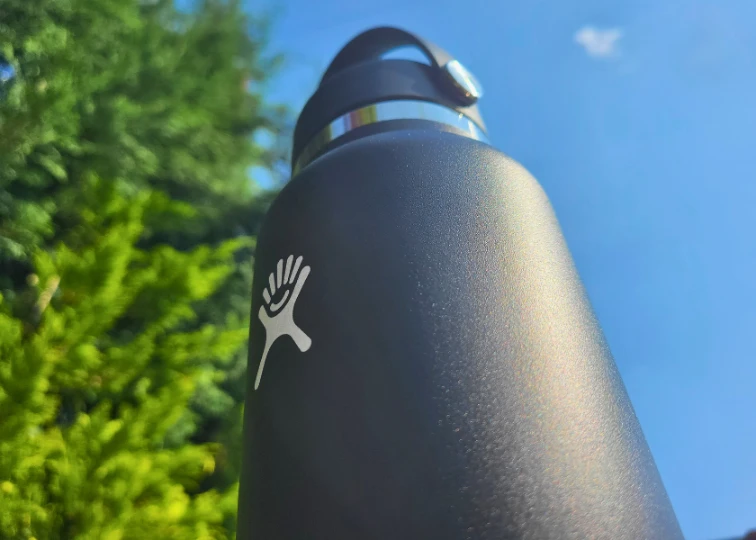 Close-up of a black Hydro Flask water bottle with a powder coating and a white logo.