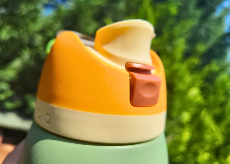 Close-up of an Owala FreeSip water bottle lid, highlighting its unique flip-top design with a built-in straw.