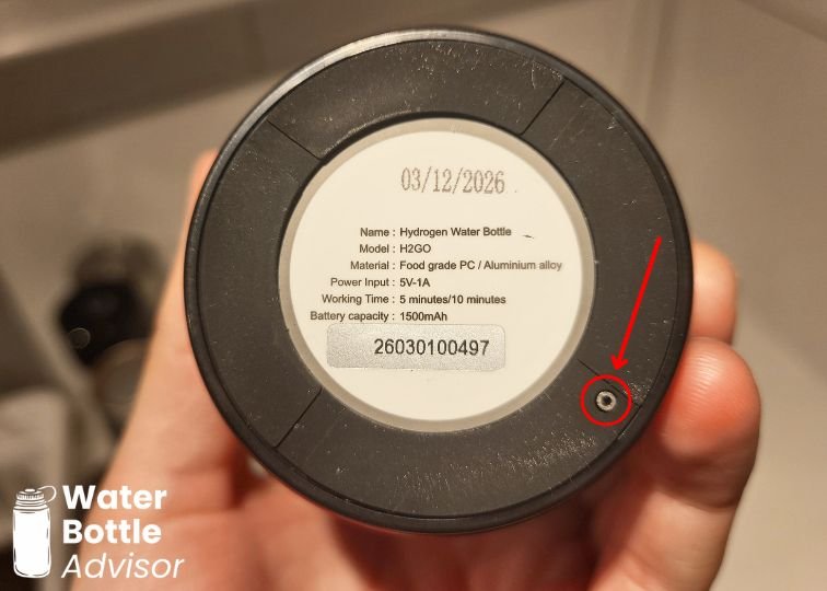 Close-up of the EVOLV hydrogen water bottle base showing the small byproduct release hole marked with a red arrow