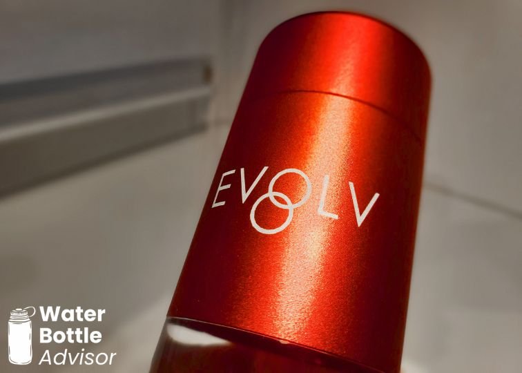 Close-up of the red EVOLV hydrogen water bottle outer shell showing the logo and metallic finish