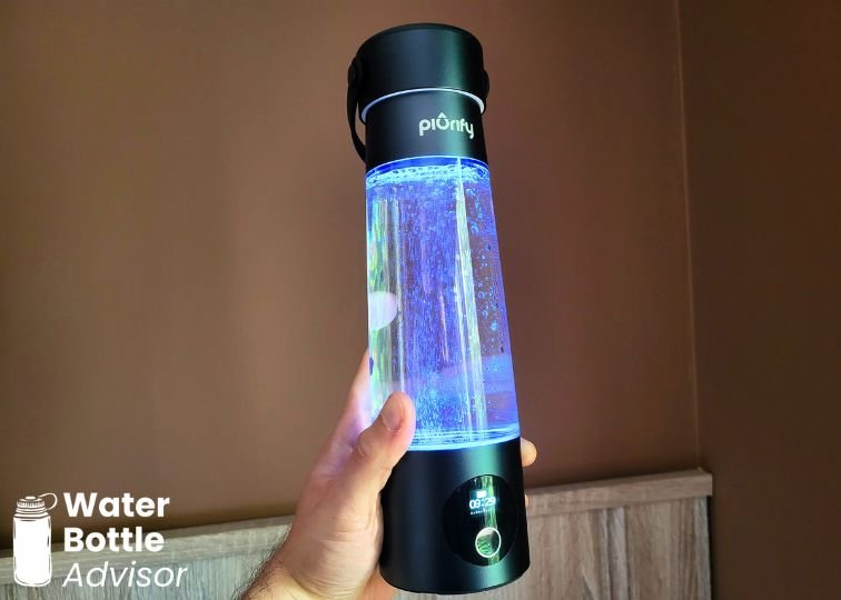 Jeremiah Kowalski holding the Piurify Hydrogenator hydrogen water bottle while it glows blue and produces hydrogen bubbles
