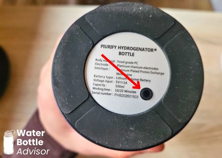 Close-up of the Piurify Hydrogenator hydrogen water bottle base showing the byproduct release vent marked with a red arrow