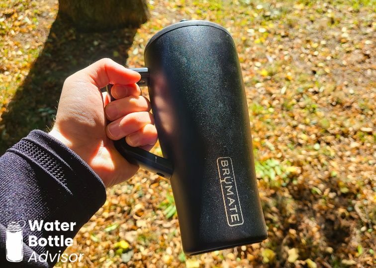 BrüMate Era 30 oz tumbler being held by the handle outdoors