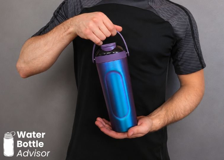 Person holding the BrüMate MultiShaker bottle by its carry handle