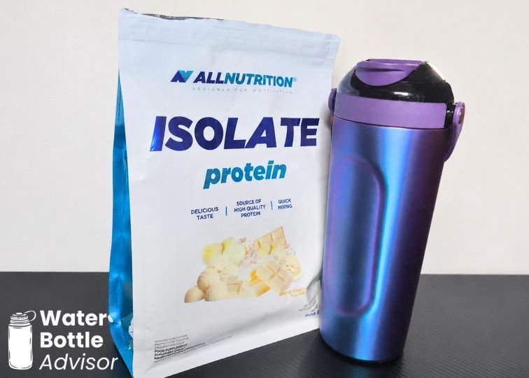 BrüMate MultiShaker bottle standing next to a protein powder package indoors