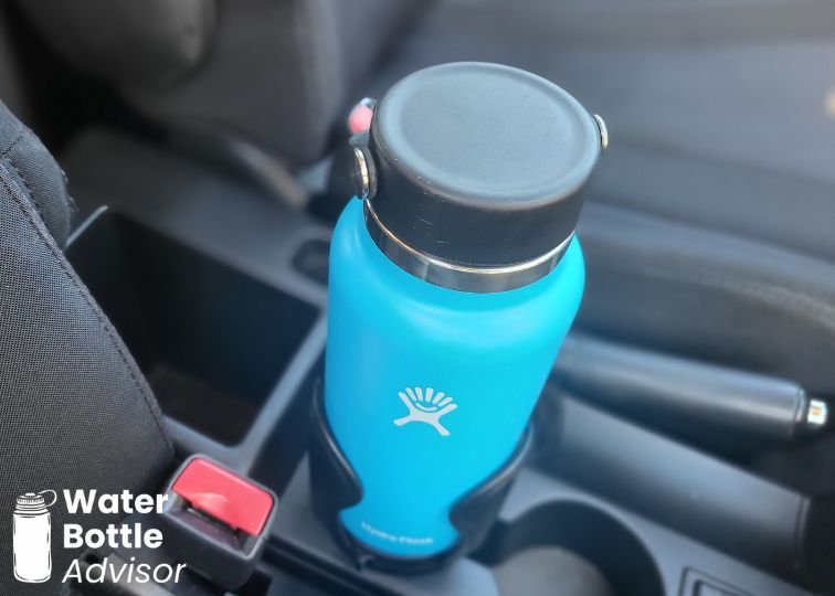 Hydro Flask 32 oz blue water bottle sitting in an adjustable car cup holder