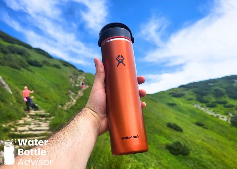 Hydro Flask Trail Series Lightweight 24 oz water bottle held on a mountain hiking trail