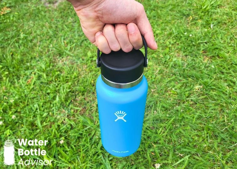 Hydro Flask Wide Mouth 32 oz bottle being carried by the Flex Cap handle outdoors
