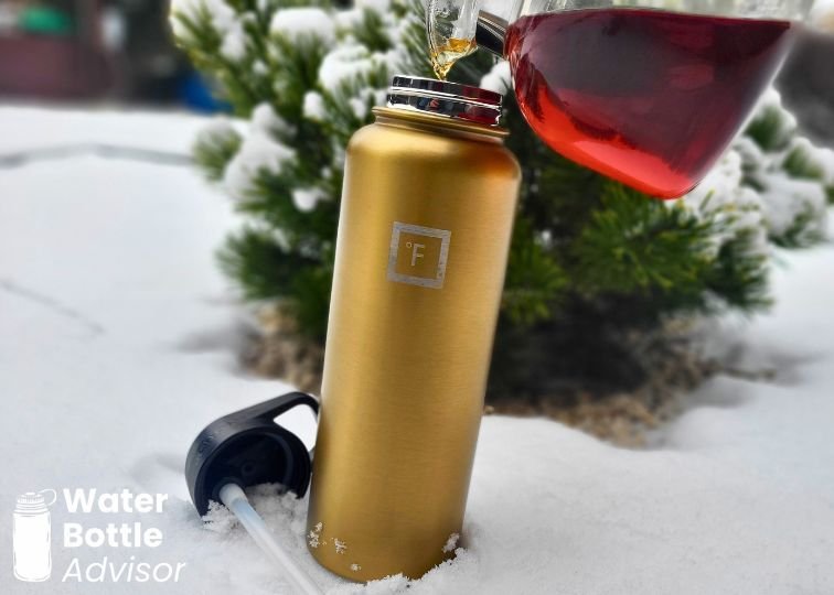 Iron Flask 40 oz bottle being filled with hot tea outdoors in the snow