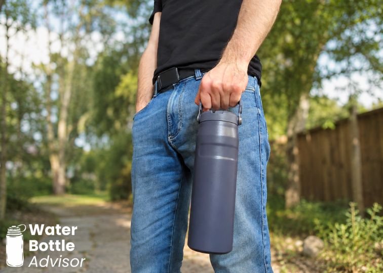 Jeremiah Kowalski carrying the Stanley IceFlow 24 oz bottle by its handle outdoors