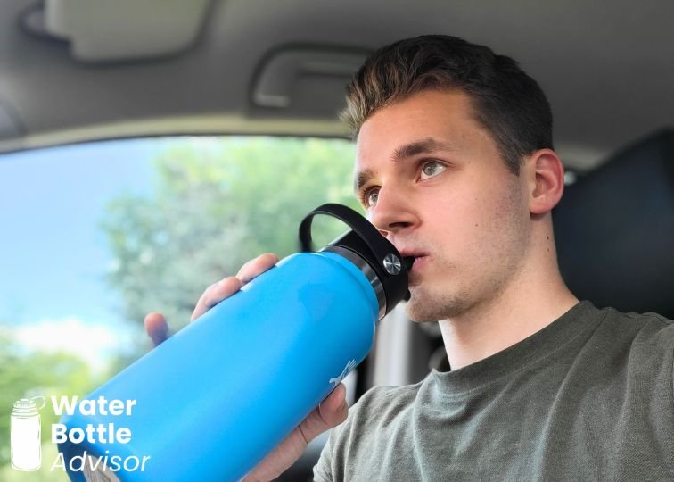 Jeremiah Kowalski drinking from a Hydro Flask Wide Mouth 32 oz blue water bottle inside a car