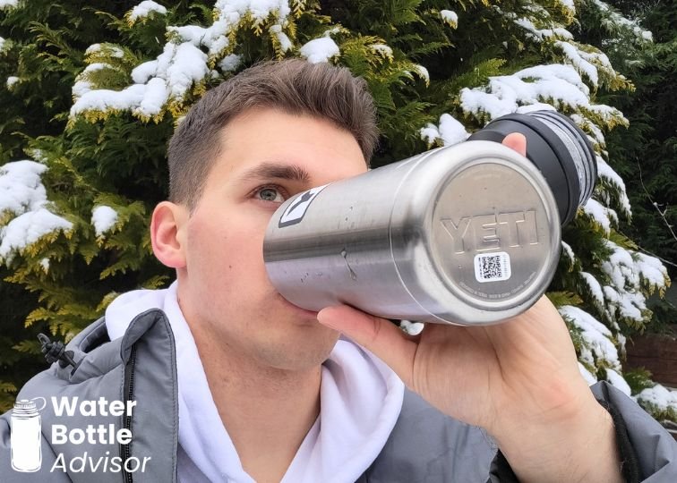 Jeremiah Kowalski drinking from the YETI Rambler 26 oz stainless steel water bottle outdoors in snowy conditions