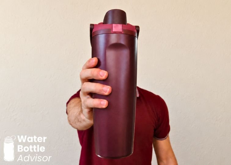 Jeremiah Kowalski holding the Owala FreeSip Sway 30 oz burgundy bottle indoors