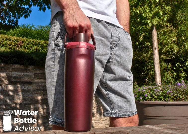 Jeremiah Kowalski holding the Owala FreeSip Sway 30 oz bottle by its carry handle outdoors