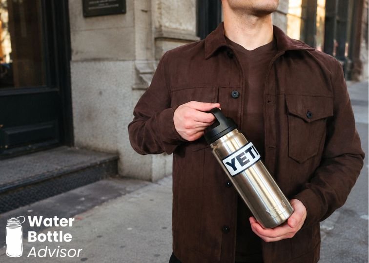 Jeremiah Kowalski holding a YETI Rambler 26 oz stainless steel water bottle outdoors in a city setting