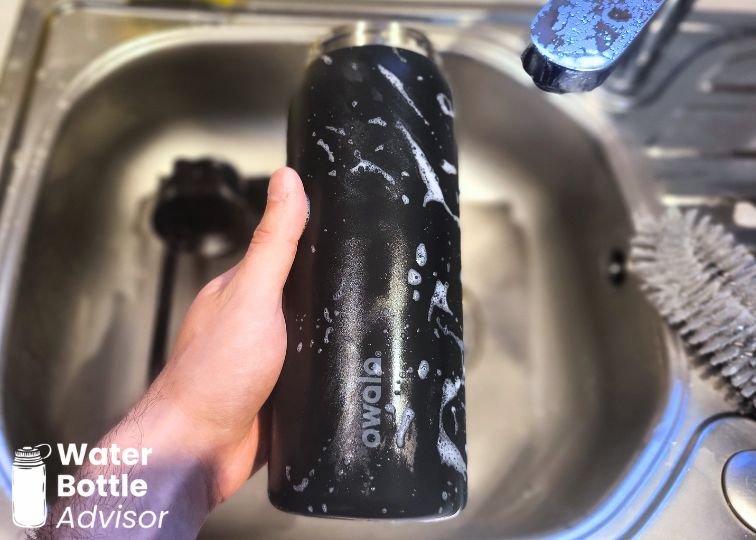 Owala FreeSip 32 oz bottle being washed with soap in a kitchen sink