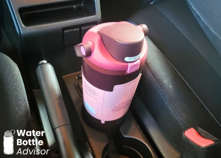 Owala FreeSip Sway 30 oz burgundy bottle sitting in a car cup holder