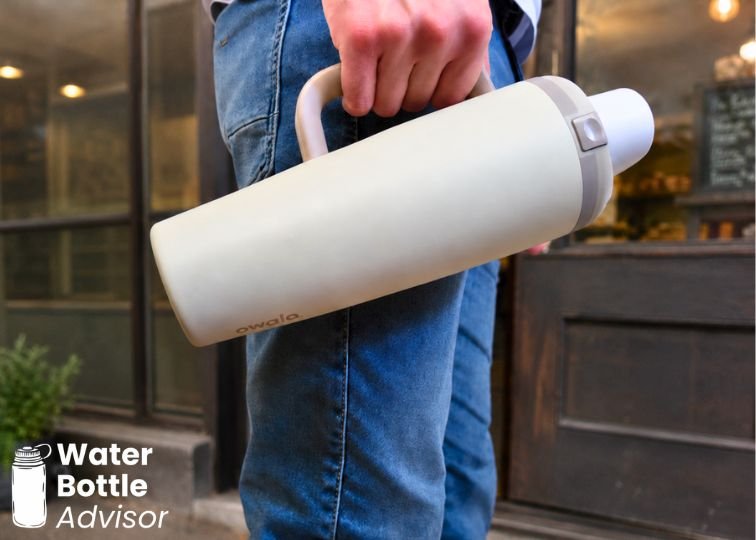 Person holding the Owala FreeSip Tumbler 30 oz by the side handle outdoors