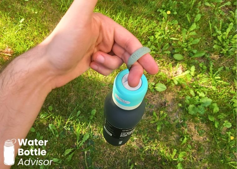 Person carrying the Owala FreeSip Twist 24 oz bottle by its loop outdoors