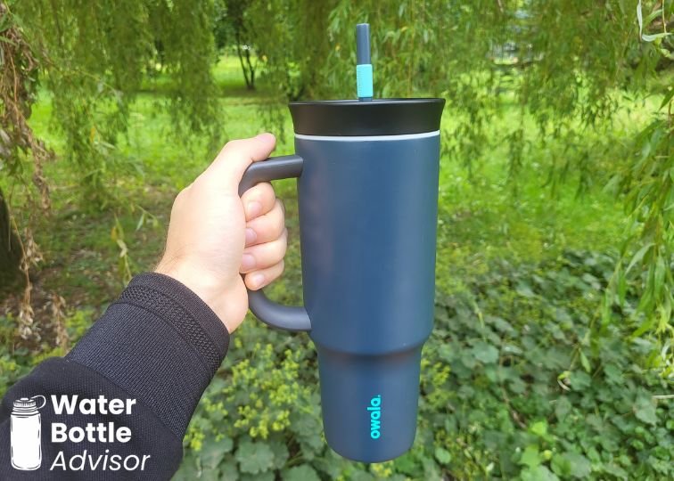 Person holding the Owala Tumbler 40 oz by the handle outdoors