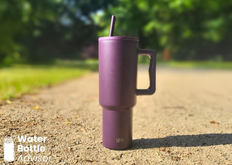 Simple Modern Trek Tumbler 40 oz standing outdoors on a gravel path