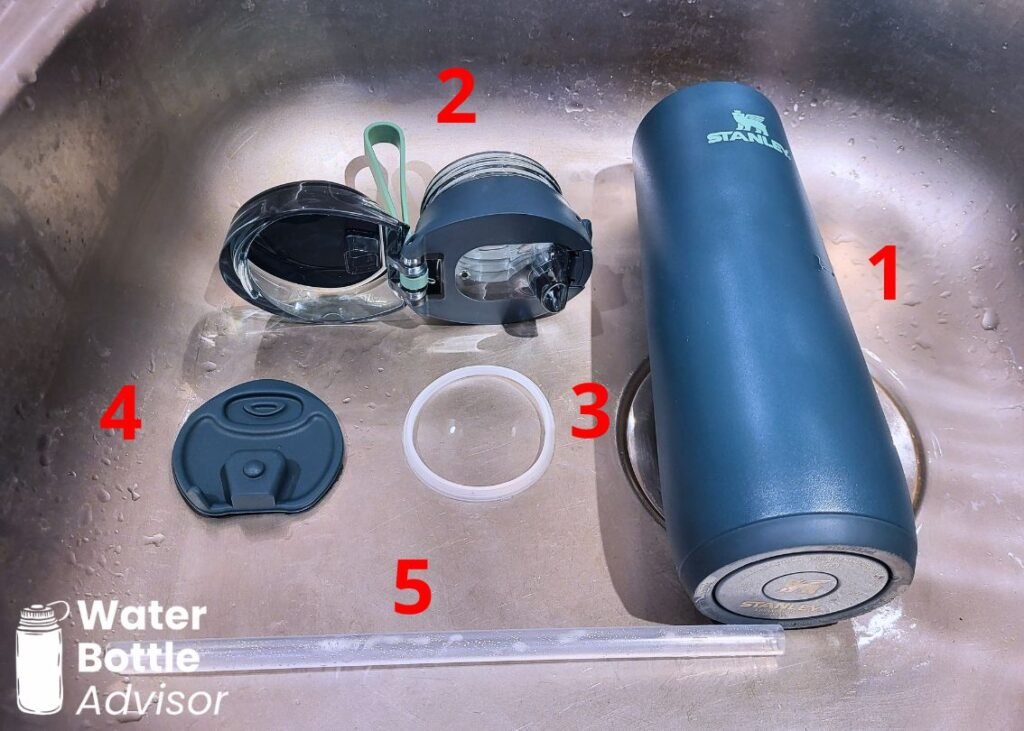 Stanley FlowState Spring Bottle 20 oz disassembled into parts for cleaning in a sink