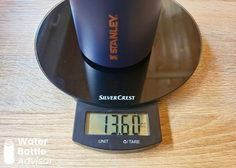 Stanley IceFlow 24 oz bottle weighed empty on a digital kitchen scale showing 13.60 oz