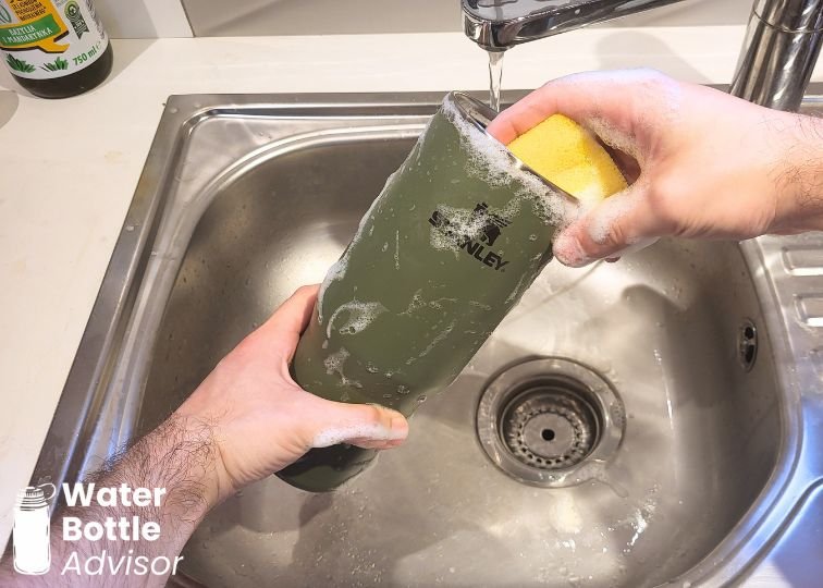 Stanley IceFlow 30 oz tumbler being washed with a sponge in a kitchen sink