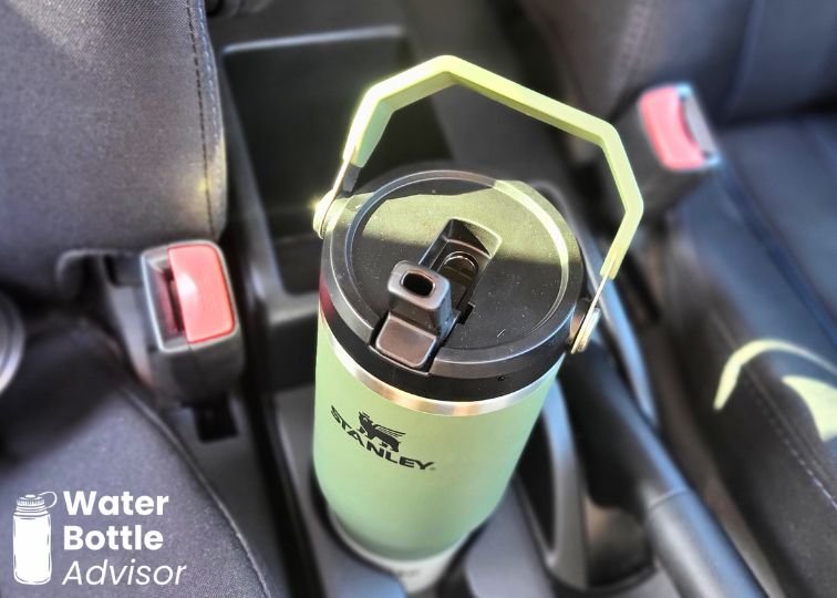 Stanley IceFlow Tumbler 30 oz sitting in a car cup holder between the front seats