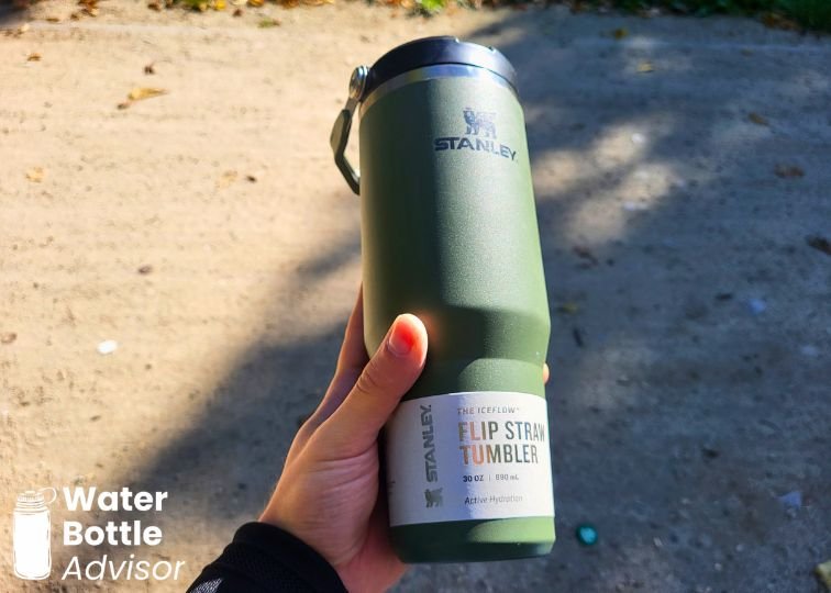 Stanley IceFlow Tumbler 30 oz in green held outdoors with the product label still attached