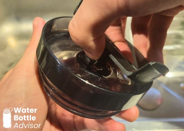 Close-up of the Stanley Quencher FlowState lid showing the rotating tab being put back into the lid