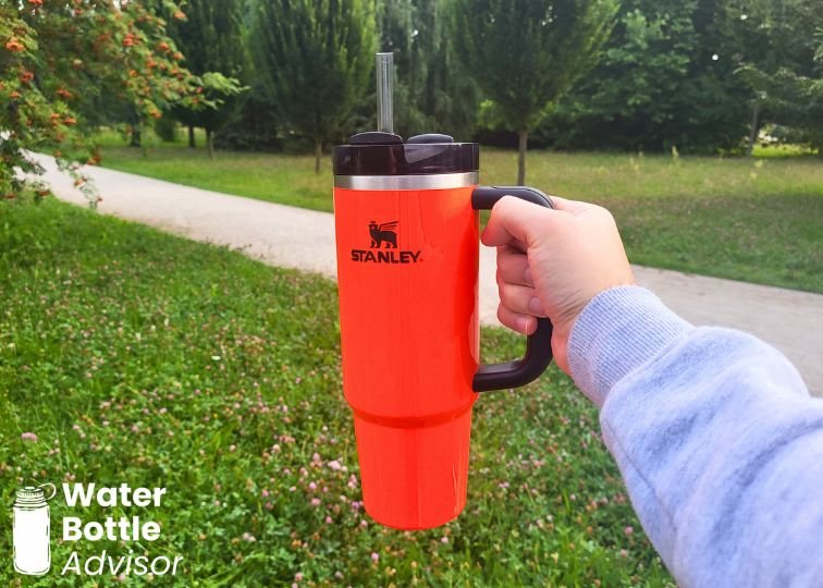 Stanley Quencher H2.0 FlowState 30 oz tumbler being carried by its side handle outdoors