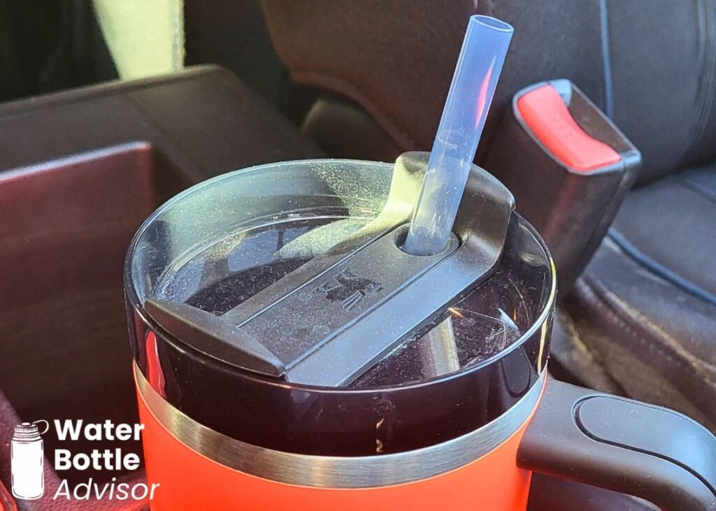 Close-up of the Stanley Quencher H2.0 FlowState 30 oz lid and exposed straw attracting dust in a car
