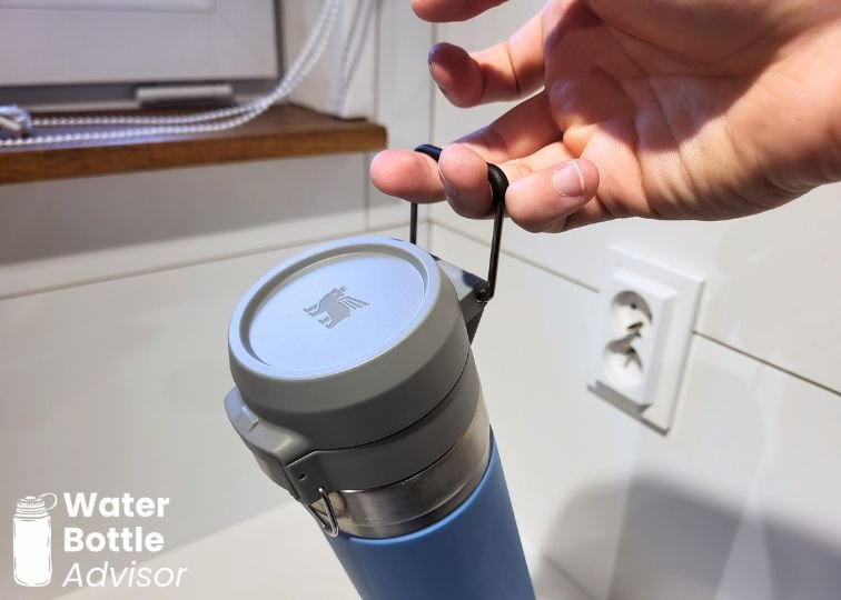 Stanley Quick-Flip Go 24 oz bottle being carried by its metal handle
