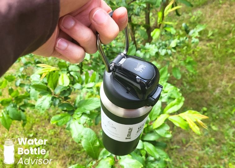 Stanley Wellspring 24 oz bottle being carried by its handle outdoors