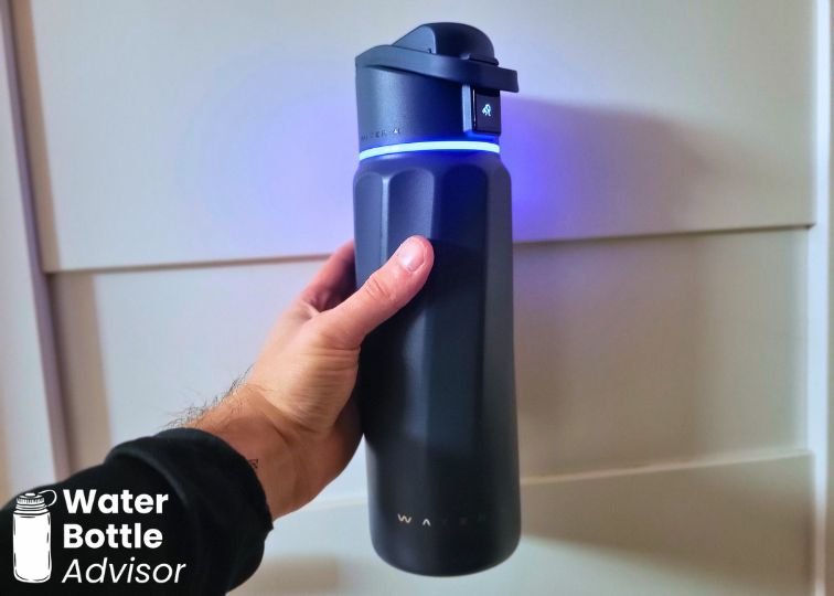 WaterH BOOST 32 oz smart water bottle glowing blue as a drink reminder while being held indoors