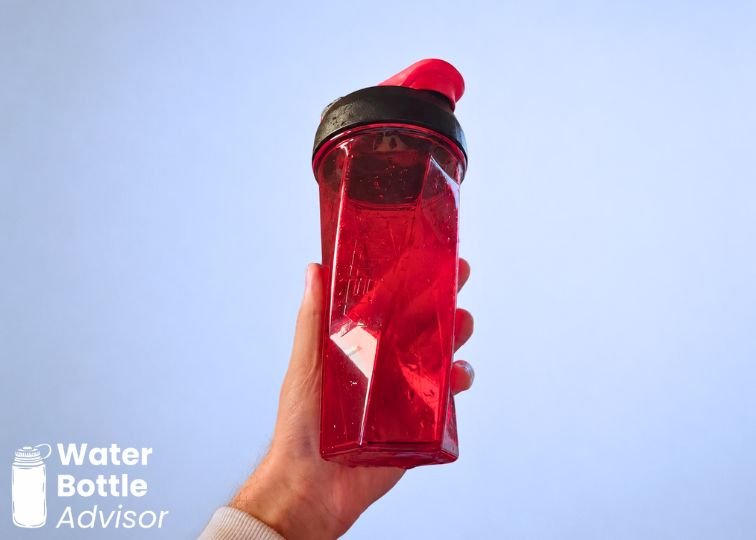 Person holding the YETI Yonder shaker bottle against a plain white wall