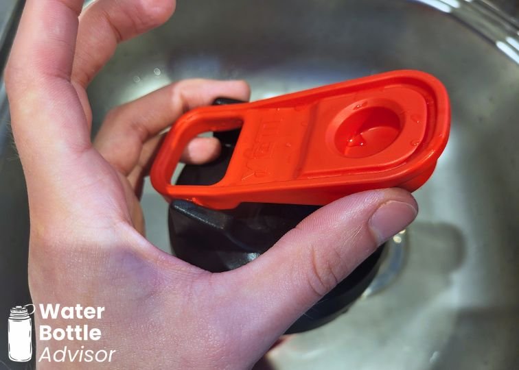 Close-up of the YETI Yonder shaker bottle lid showing the red flip cap and carry handle
