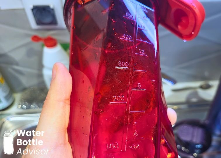 Close-up of the YETI Yonder shaker bottle showing the measurement markings on the red transparent body